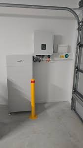 FoxESS home battery stack and inverter installed next to a yellow safety pole
